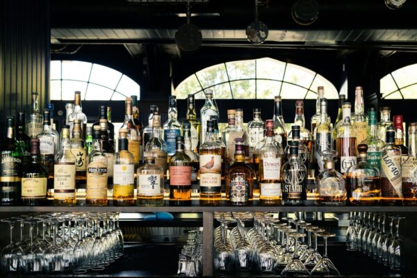 Happy Hour Barra de Bar con muchas bptellas de distintos alcoholes y licores